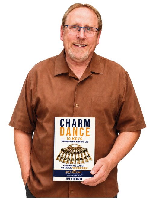 Jim Krigbaum smiling and holding a copy of CHARM DANCE